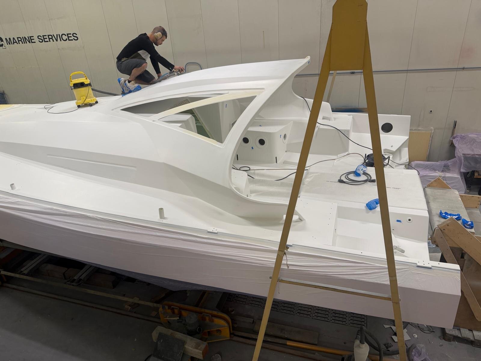 A yard worker finishing the new, larger cockpit roof for skipper protection